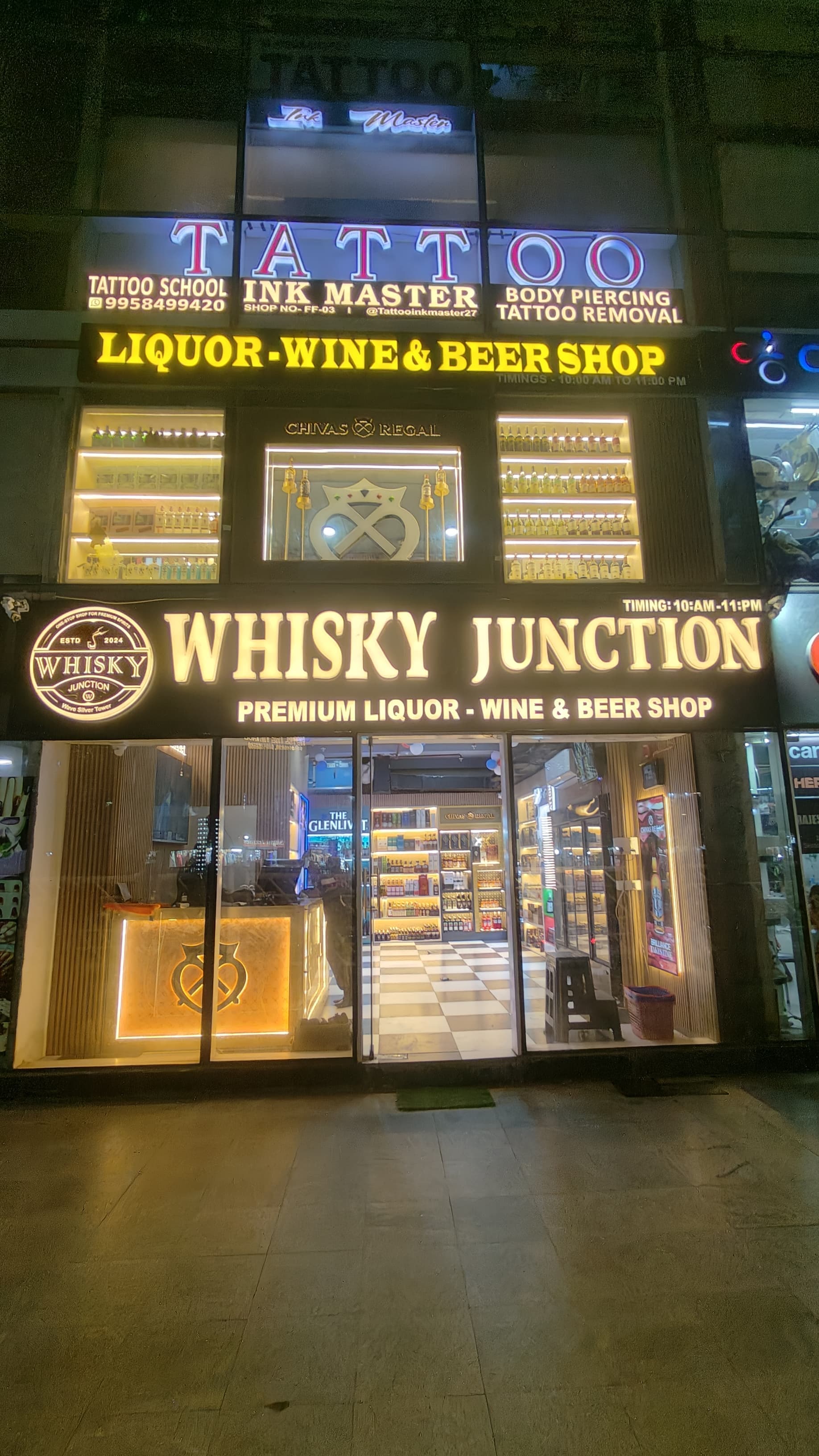 Liquor shop exterior with branding and visible display of wine and whisky bottles.
